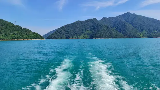 推波而行，碧水被划开一道长长的白练。远处青山如黛，连绵成一卷未干的水墨。天空澄澈，仿佛要将这满湖的蓝，都染作云裳。