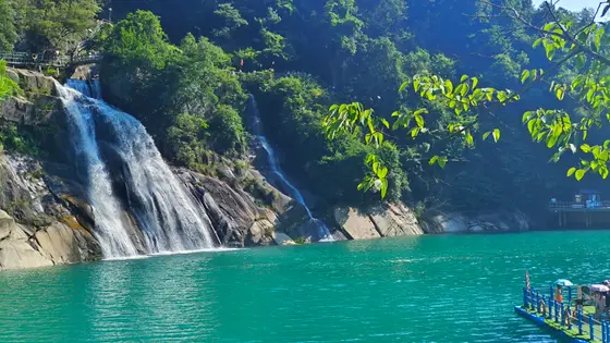 银瀑垂崖，如素练轻悬，溅起碎玉满潭。碧水凝翠，映照山色空蒙，一池碧波轻漾。林荫深处，光影婆娑，绿叶低语着夏日的悠然。