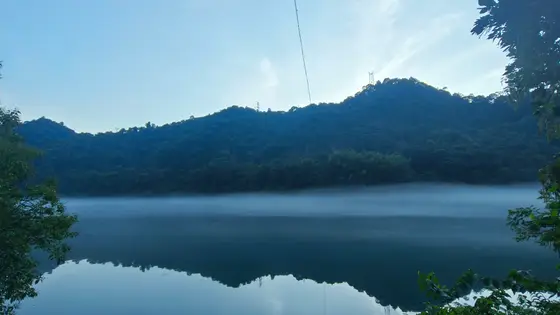 薄雾如轻纱，浮在静谧的湖面之上。远山披着墨色的林袍，在天水间沉睡。树影与山影相拥，倒映在镜中，分不清哪个是真实，哪个是梦。