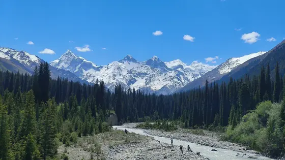 碧空如洗，几缕云絮轻抚雪山的银冠。  
森林如墨绿的潮水漫过山谷，拥抱着冰川融出的溪流。  
人影散落河滩，仿佛自然手稿上灵动的标点。
