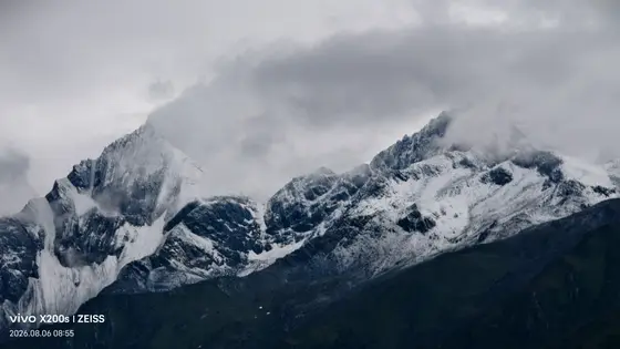 云雾轻抚着雪峰的肩膀,让峻峭的棱角在朦胧中若隐若现。冰川如凝固的瀑布,从山脊流淌而下,诉说着时间与自然的寂静对话。深色的山体托起一片银白的世界,仿佛大地在这里屏住了呼吸,只余风与雪的低语。