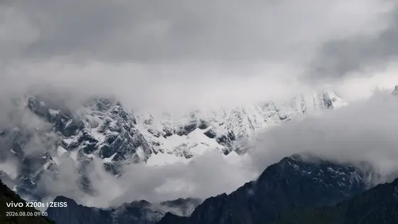 云雾轻纱漫卷,雪峰时隐时现,似仙境垂落人间一隅。
山峦披银装,冰痕刻岁月,静谧中自有雷霆万钧之力。
云端之上,光与影交织成永恒的诗行。