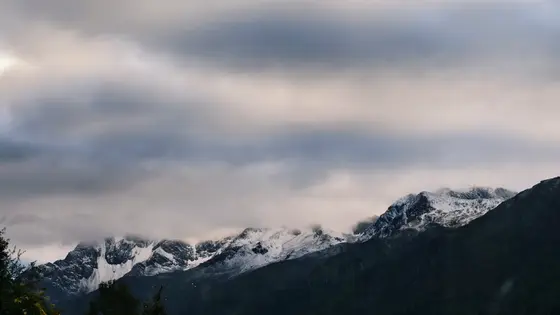 云雾如轻纱,缠绕着雪峰的衣襟。天光在灰蓝间流淌,为山巅镀上一层碎银。白雪沉默地铺展,仿佛亘古未醒的梦境。