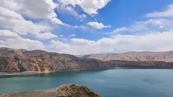 蓝天如洗，白云悠闲地飘过天际。湖水静谧，映照着远山的轮廓。荒原静默，仿佛在诉说着千年的故事。风轻云淡，一切都沉浸在自然的怀抱中。