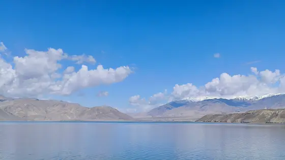 天空之镜铺展在天地之间，云朵是倒映的雪山，山脉是天空的裙摆。湖水将蔚蓝酿成一汪寂静，风也放轻了脚步。唯有时间，在这片空旷里轻轻流淌。